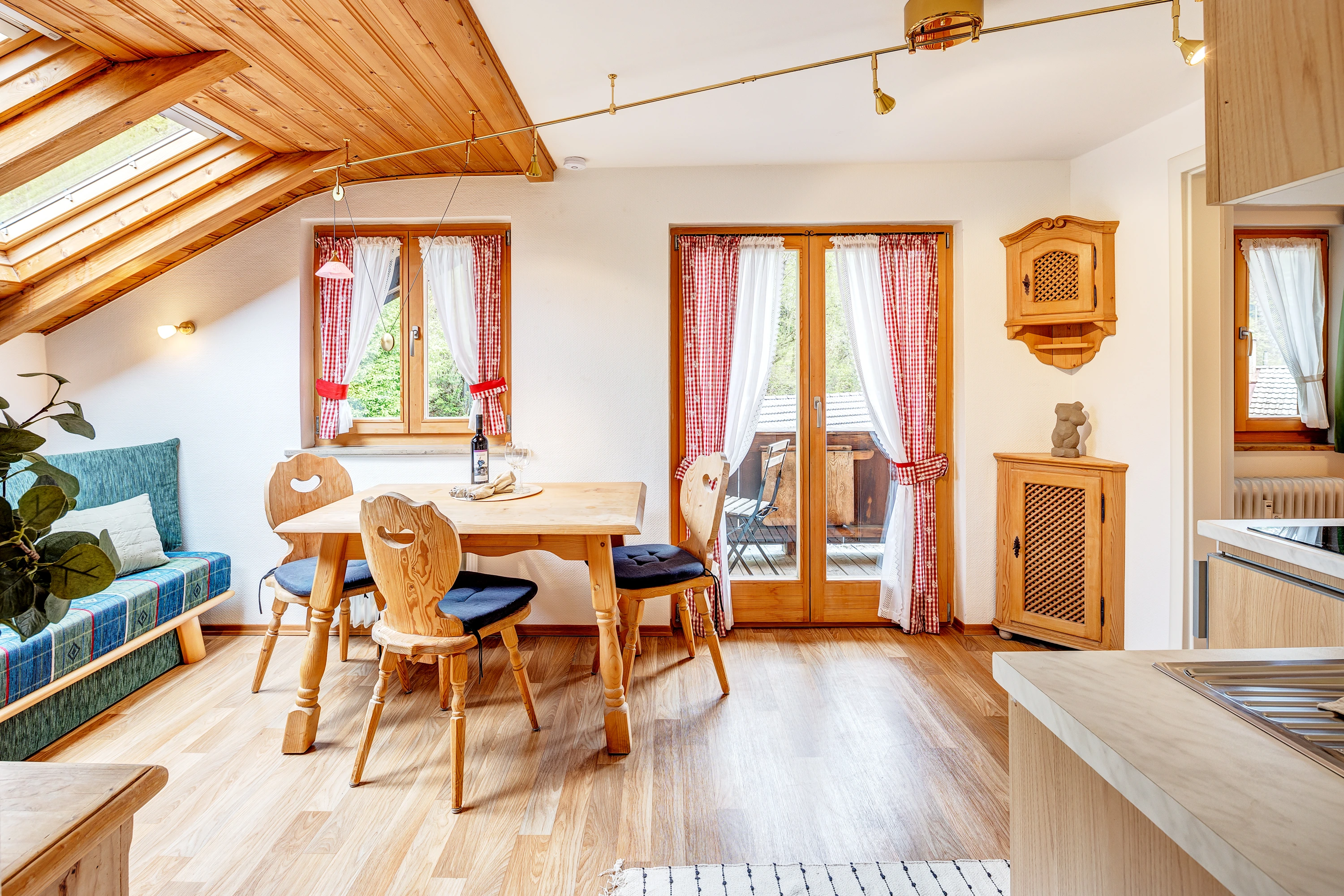 Gemütliche Dachgeschosswohnung im alpenländischen Stil mit Holzdecke, Esstisch und Sitzbank mit Kissen
